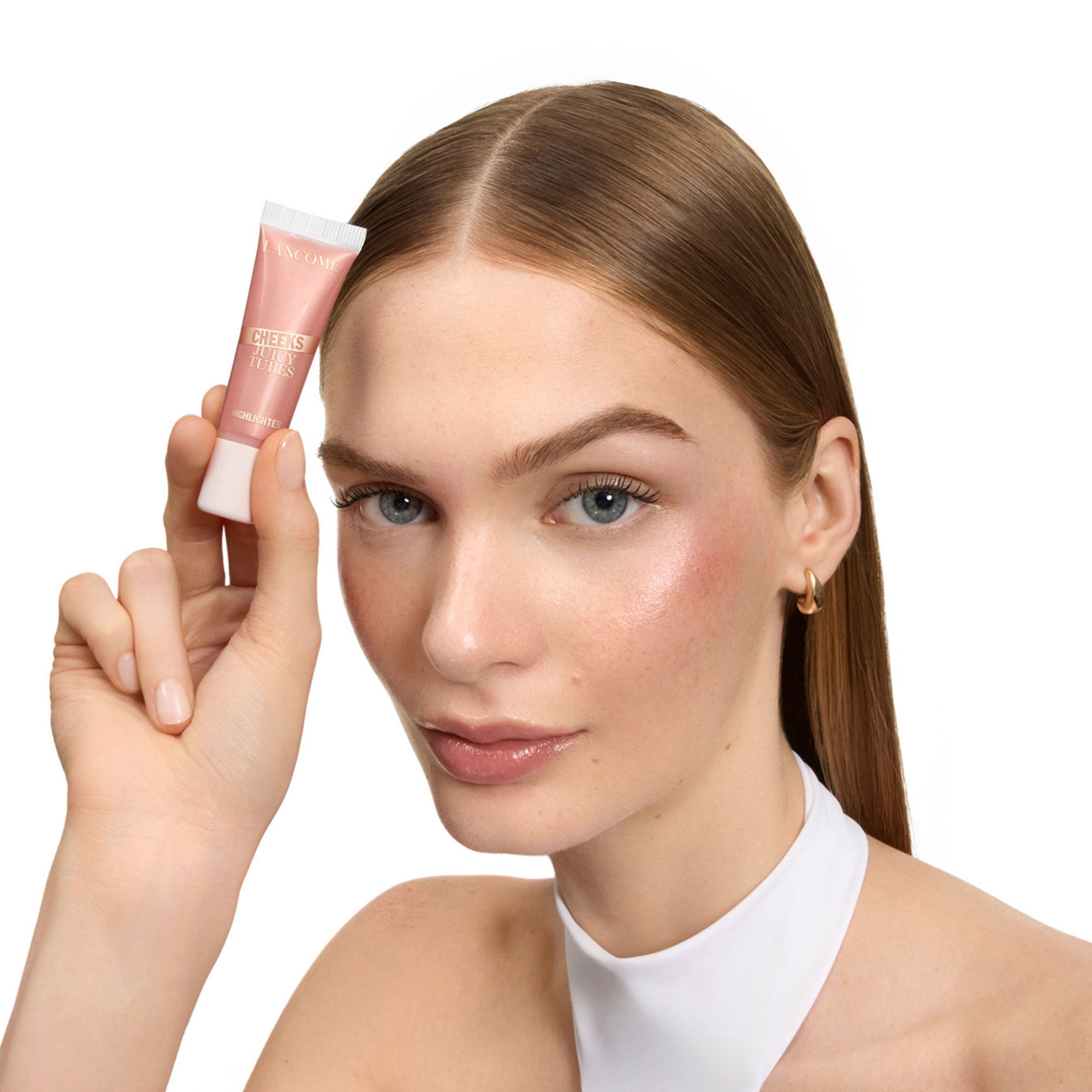 Model with light skin showing a luminous highlighter finish.