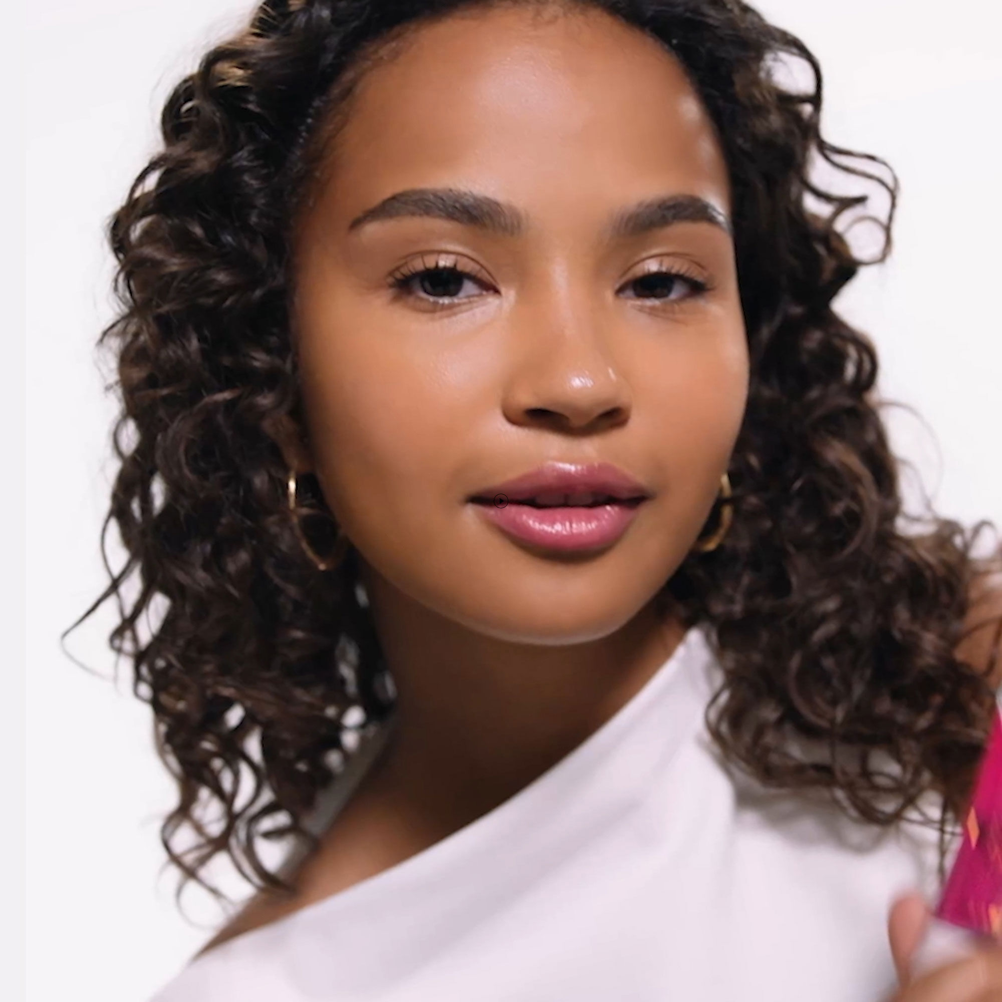 Application tutorial featuring a model with curly hair.