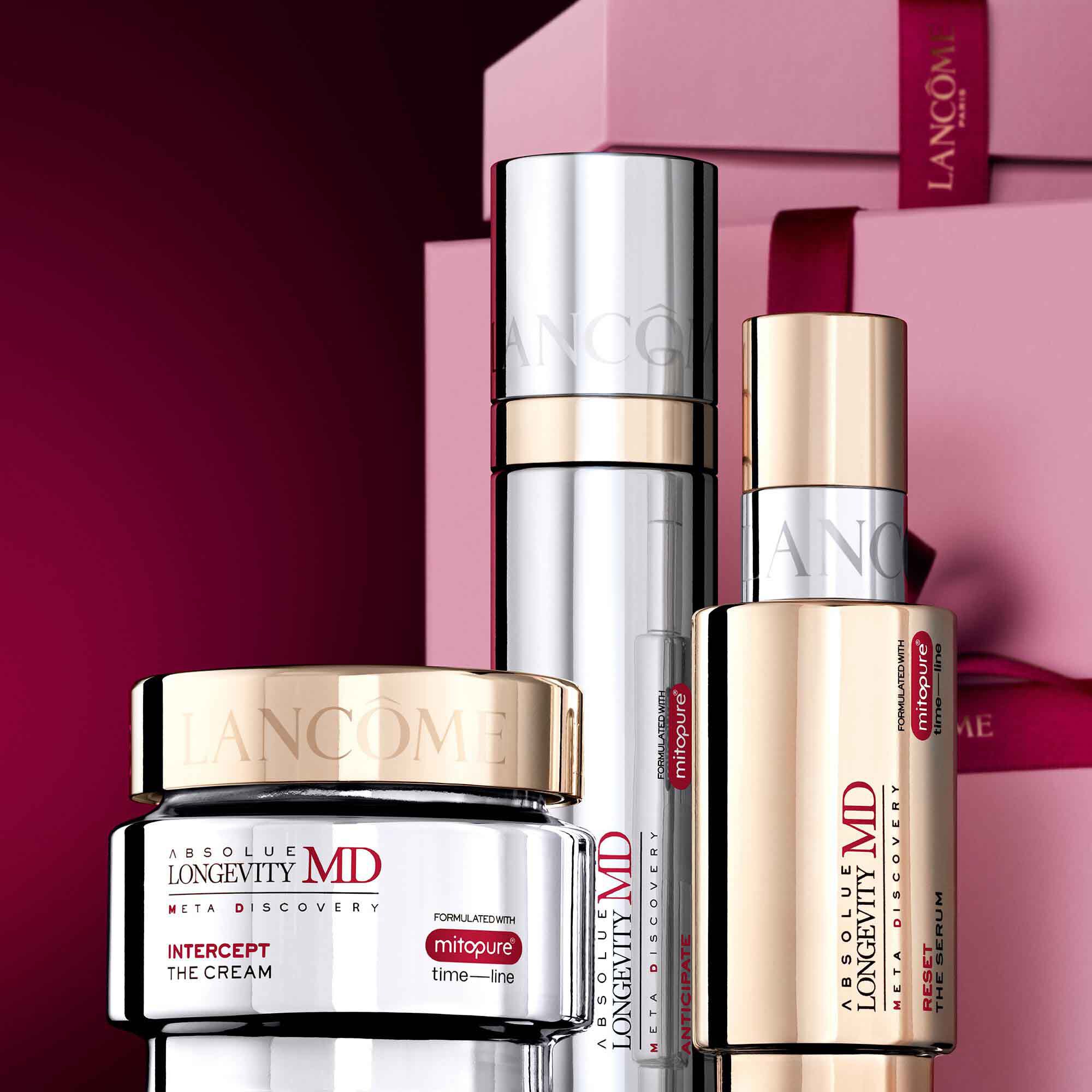 Image of Absolue MD range standing in front of a pile of pink and dark red gift boxes, set against a dark red background.